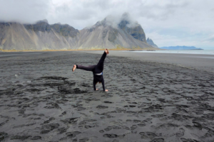 Patricia doing a kart wheel on a beach in Iceland