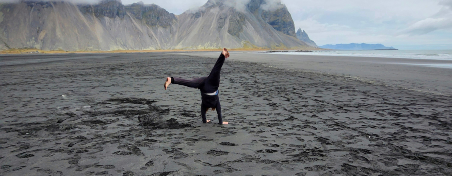 Patricia doing a kart wheel on a beach in Iceland