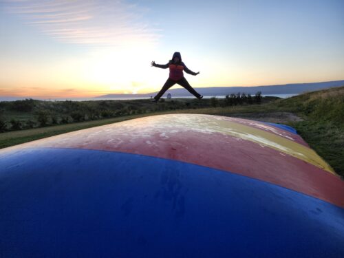 Patricia jumping on a trampoline at a campsite in Iceland.