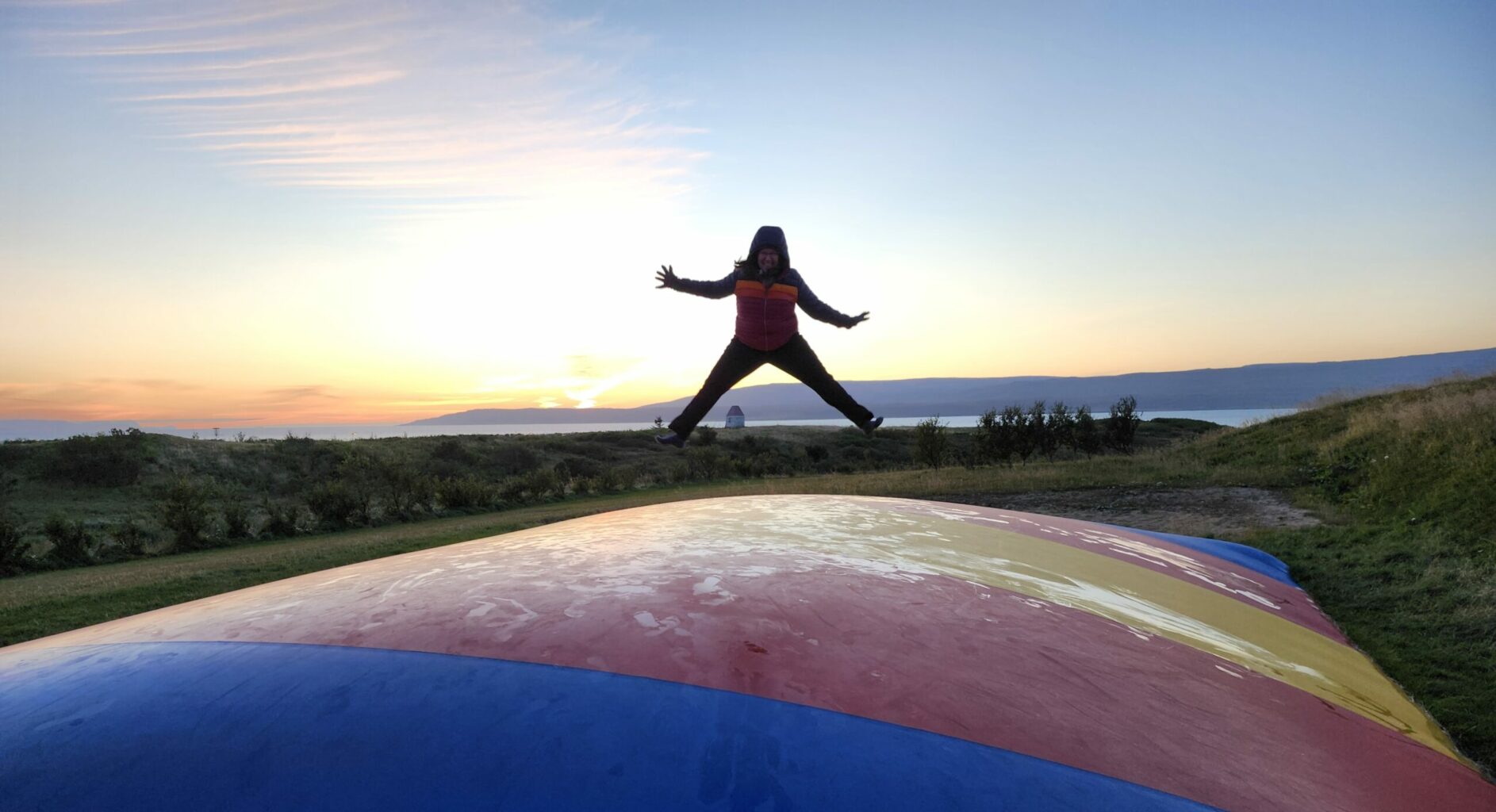 Patricia jumping on a trampoline at a campsite in Iceland.