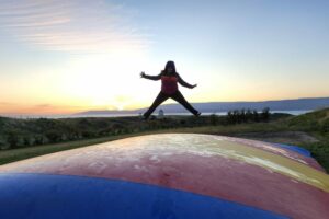 Patricia jumping on a trampoline at a campsite in Iceland.