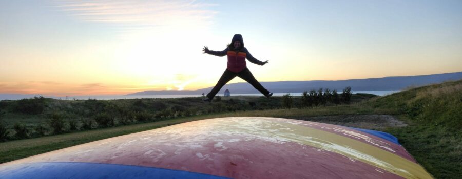 Patricia jumping on a trampoline at a campsite in Iceland.